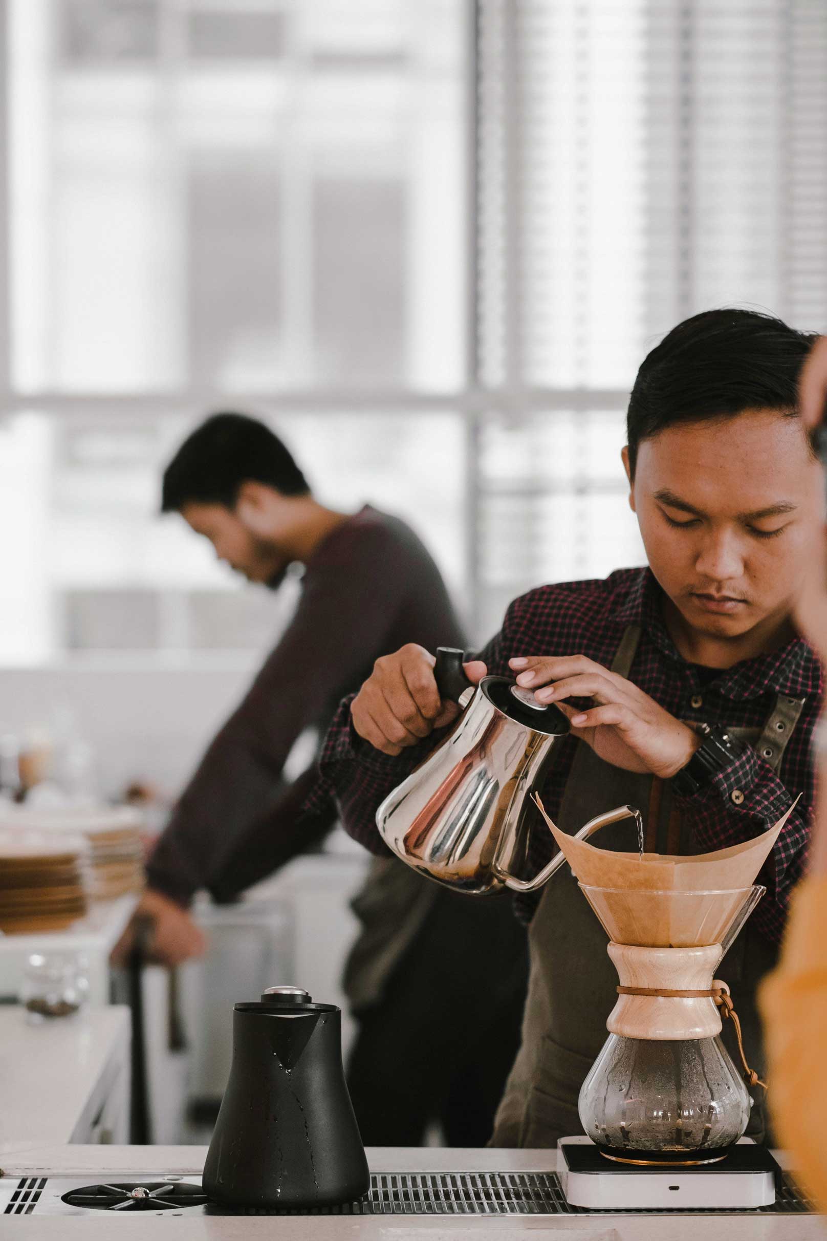Barista brewing coffee at a local coffee shop near CORE Rego Park apartments in Queens, NY.