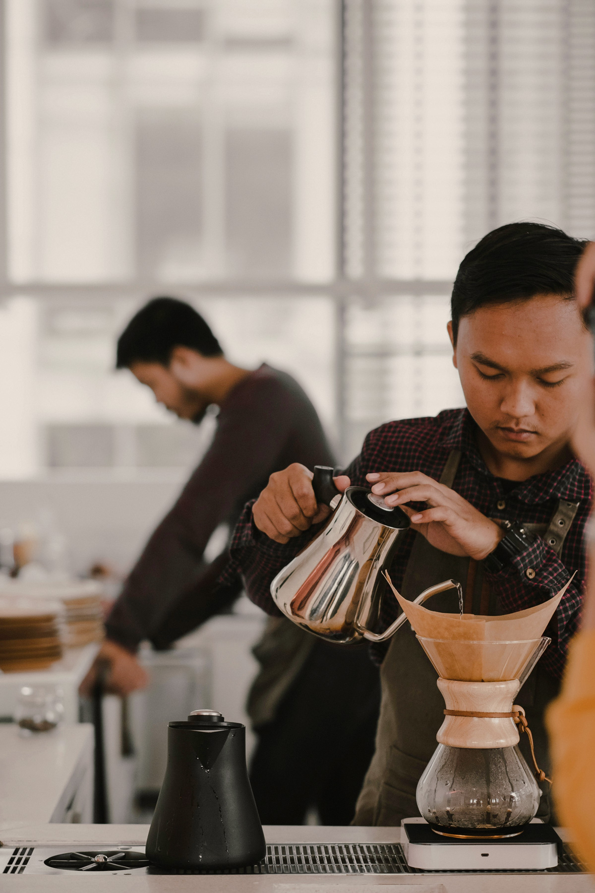 Barista brewing coffee at a local coffee shop near CORE Rego Park apartments in Queens, NY.